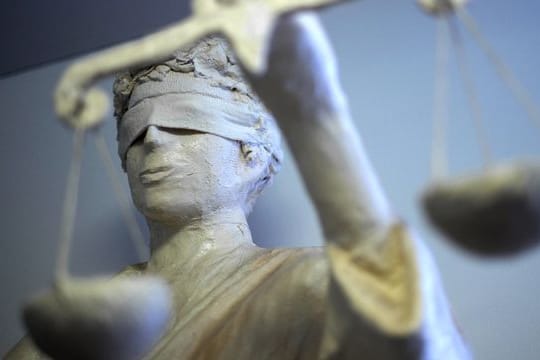 Eine Statue der Justitia hält die Waage