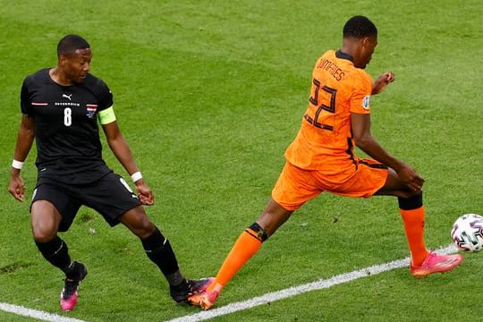 Österreichs David Alaba (l) kommt zu spät und foult den Niederländer Denzel Dumfries und verursacht einen Elfmeter.