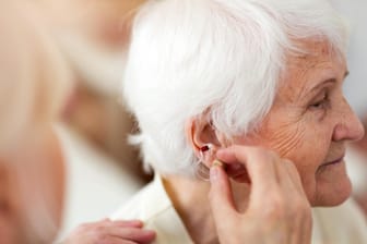 Eine Frau bekommt ein Hörgerät (Symbolbild): Die Ausgaben dafür können Senioren steuerlich geltend machen.