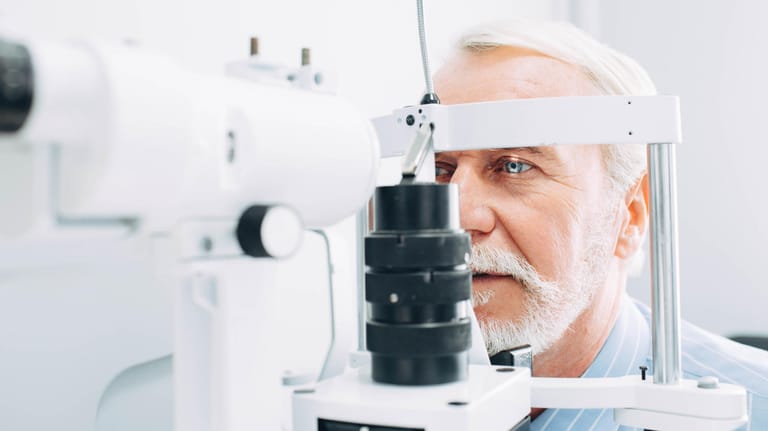 Ein älterer Mann bei einer Augenuntersuchung; Eine Makuladegeneration entsteht meist im höheren Alter.