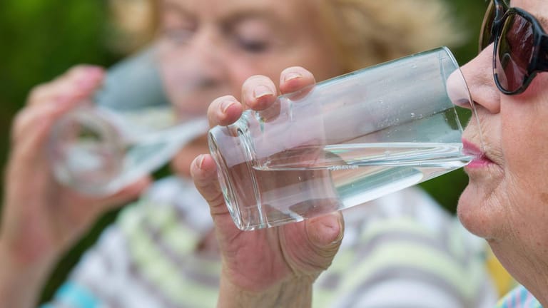 Zwei ältere Frauen trinken an einem heissen Sommertag ein Glas Wasser (Archivbild). Das Gesundheitsministerium will Senioren besser schützen.