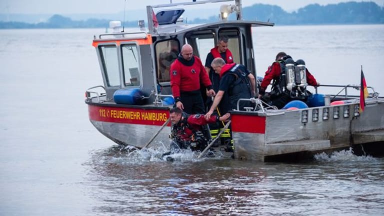 Ein Taucher der Feuerwehr Hamburg steigt von einem Kleinboot ins Wasser: In der Elbe wurde nach einem Jugendlichen gesucht.