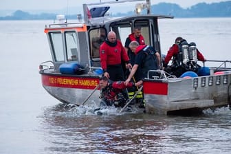 Ein Taucher der Feuerwehr Hamburg steigt von einem Kleinboot ins Wasser: In der Elbe wurde nach einem Jugendlichen gesucht.