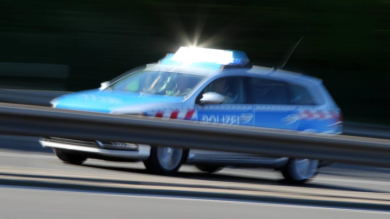 Polizeiwagen auf der A111 im Norden Berlins: Ein Auto hat nach einem Unfall Feuer gefangen.