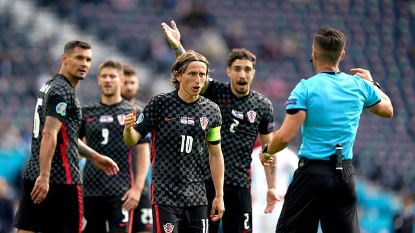 Luka Modric (M) und seine Mitspieler im Diskurs mit dem Schiedsrichter.