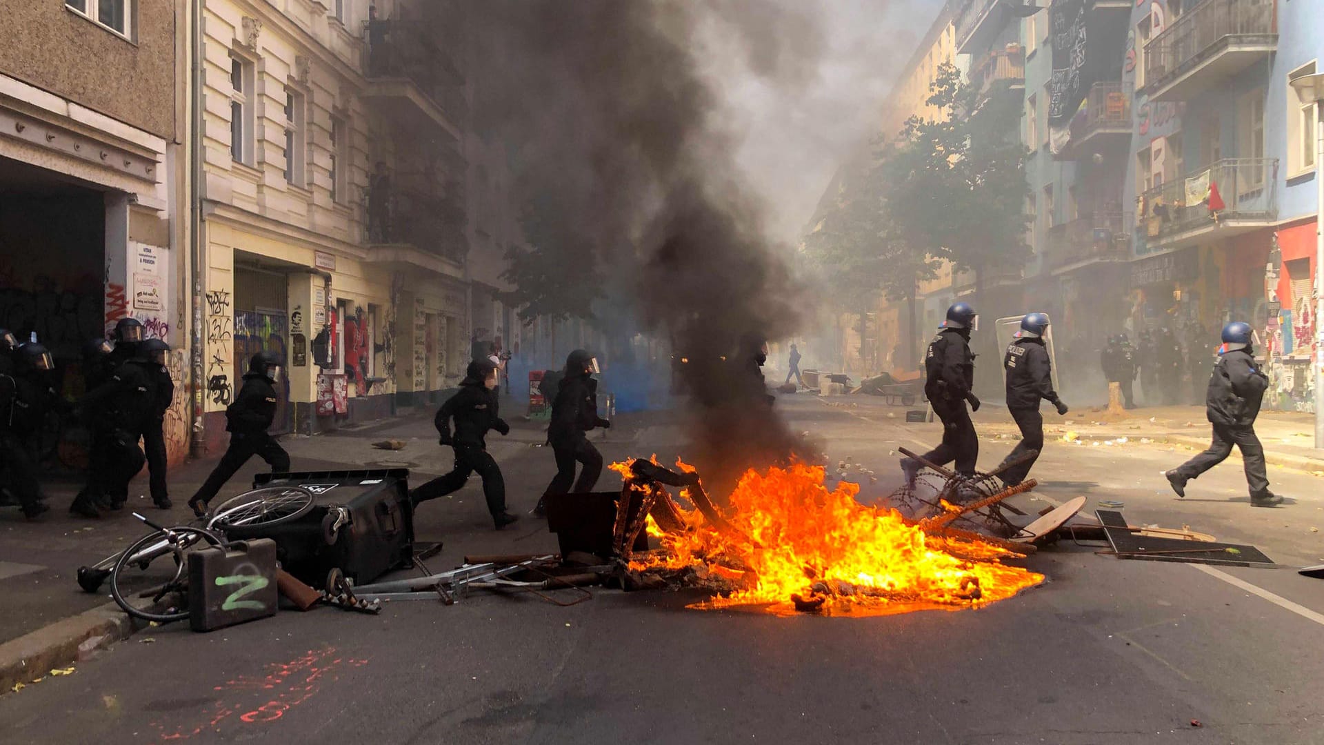 Polizisten laufen der Rigaer Straße in Berlin-Friedrichshain an einer brennenden Barrikade vorbei: Vor der Brandschutzprüfung in der "Rigaer 94" kam es zu Angriffen auf Beamte. Polizisten laufen der Rigaer Straße in Berlin-Friedrichshain an einer brennenden Barrikade vorbei: Vor der Brandschutzprüfung in der "Rigaer 94" kam es zu Angriffen auf Beamte.
