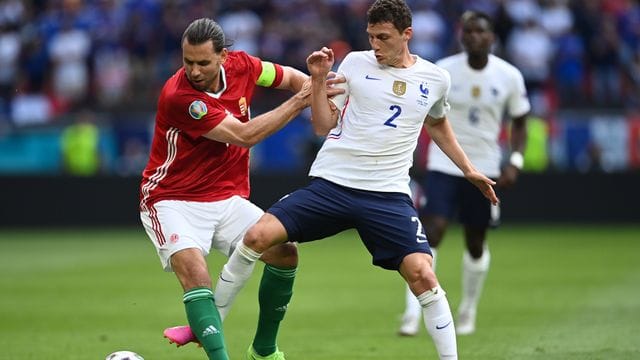 Ungarns Adam Szalai (l) kämpft mit Frankreichs Benjamin Pavard um den Ball.