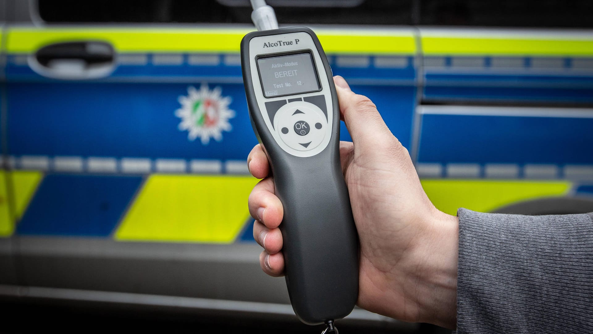Eine Hand mit Alkoholtester vor einem Polizeiwagen (Symbolbild): Die mutmaßliche Fahrerin hatte mehr als 1,2 Promille im Blut. Eine Hand mit Alkoholtester vor einem Polizeiwagen (Symbolbild): Die mutmaßliche Fahrerin hatte mehr als 1,2 Promille im Blut.