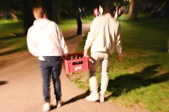 Jugendliche tragen einen Kasten Bier in einen Park (Symbolbild): Viele junge Erfurter haben das Sommerwetter zum Feiern genutzt.