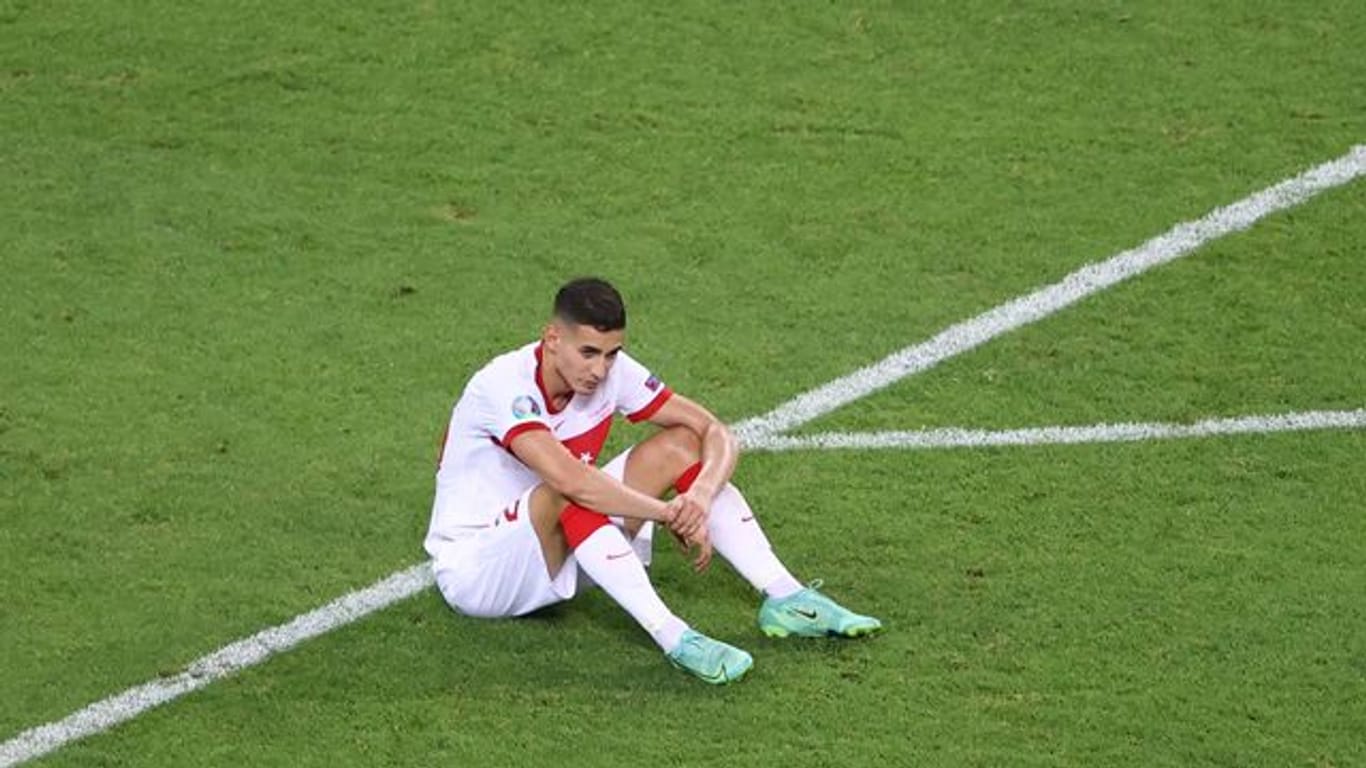 Der türkische Nationalspieler Mert Müldür sitzt nach dem EM-Aus auf dem Rasen.