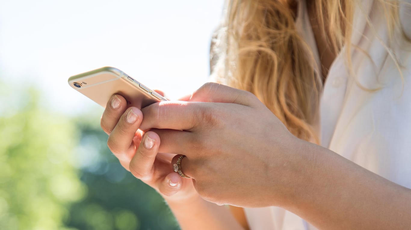 Eine Frau am Smartphone (Symbolbild): Vorsicht vor Betrugs-SMS.
