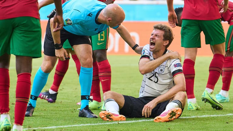 Schmerzverzerrtes Gesicht: Thomas Müller im Spiel gegen Portugal, Schiedsrichter Anthony Taylor fragt nach.
