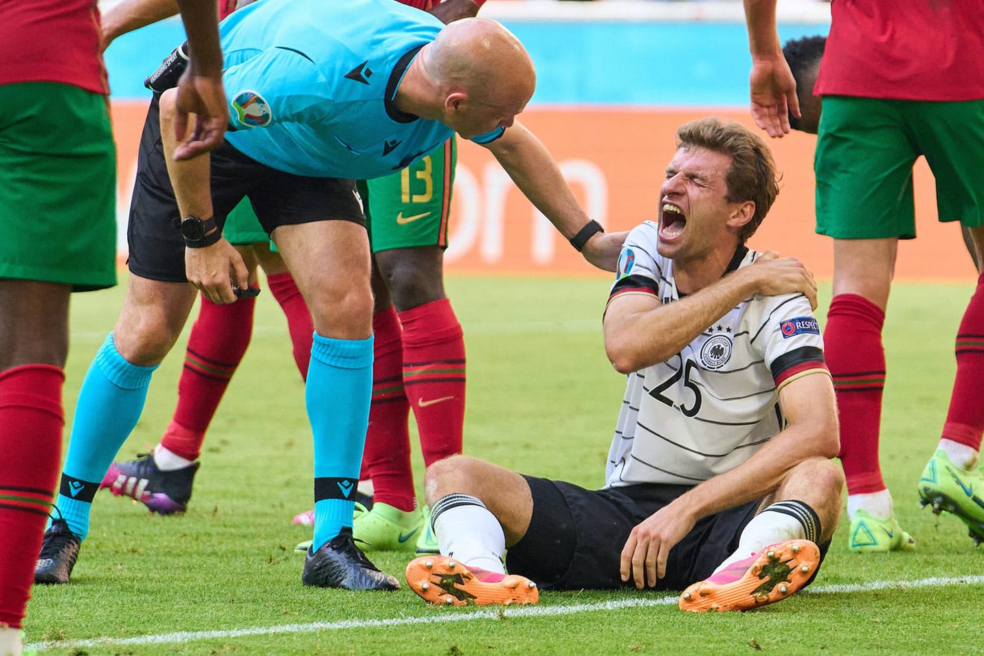 Schmerzverzerrtes Gesicht: Thomas Müller im Spiel gegen Portugal, Schiedsrichter Anthony Taylor fragt nach.