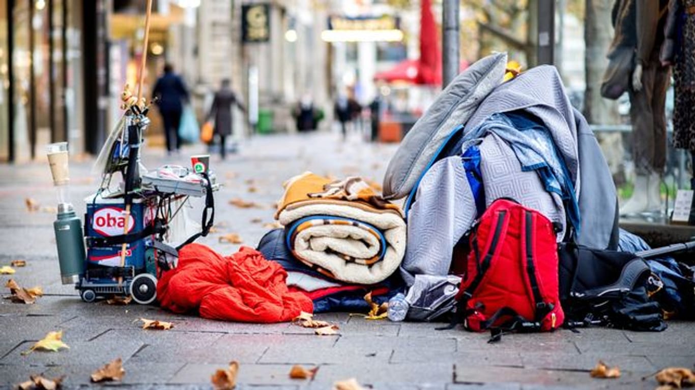 Die Habseligkeiten eines Obdachlosen liegen auf einem Bürgersteig in der Innenstadt (Symbolbild): Viele Obdachlose meiden die Sammelunterkünfte.