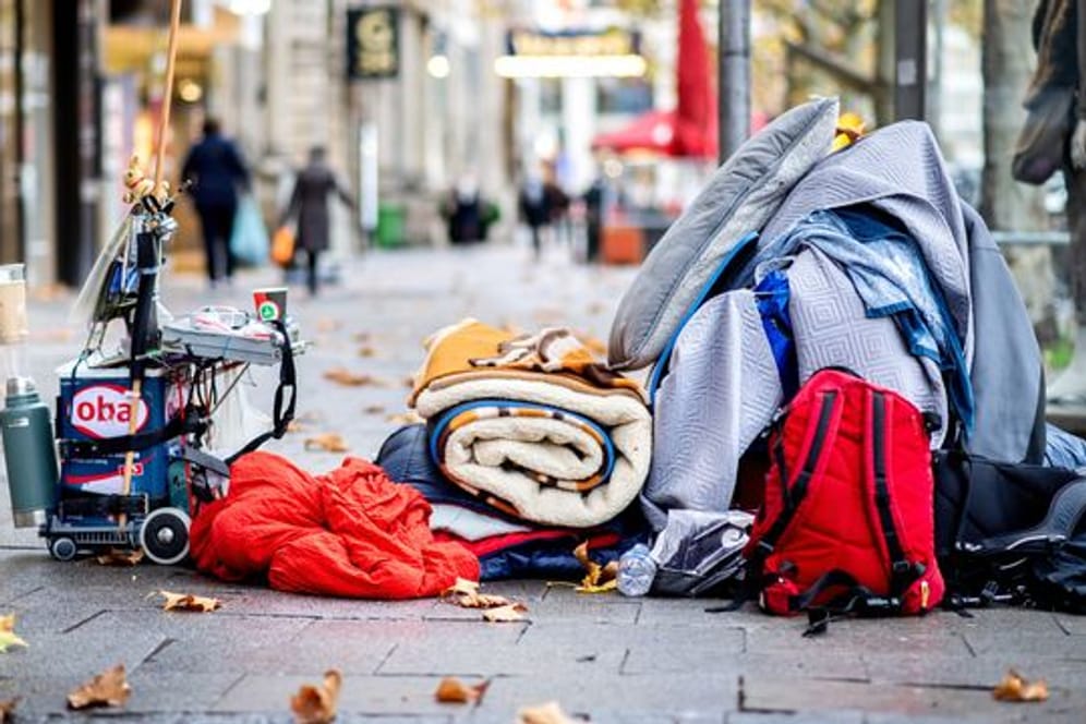Die Habseligkeiten eines Obdachlosen liegen auf einem Bürgersteig in der Innenstadt (Symbolbild): Viele Obdachlose meiden die Sammelunterkünfte.