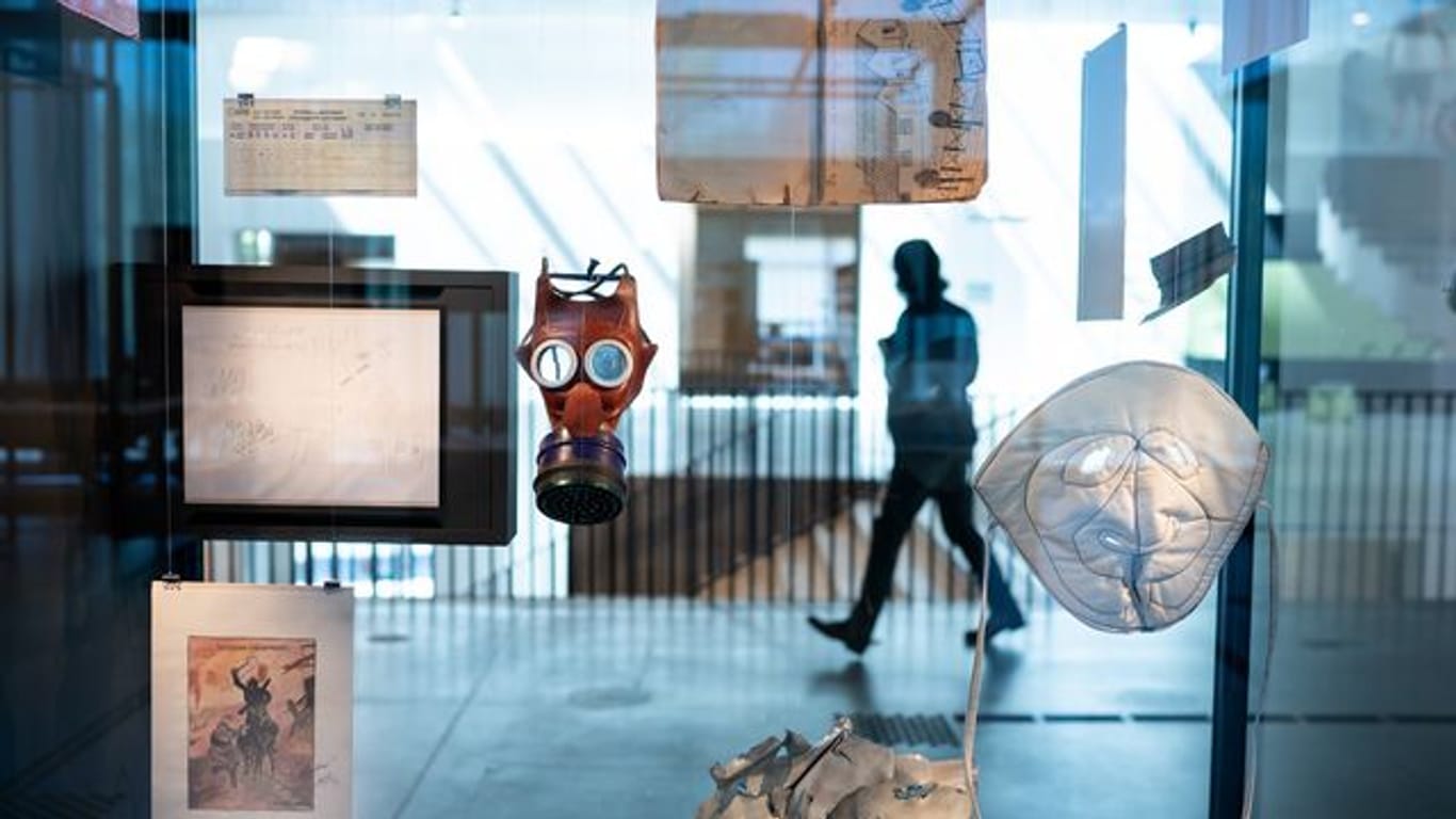 Eine Kindergasmaske und eine Frostschutzmaske hängen in einer Vitrine in der Ausstellung des neuen Dokumentationszentrums der Stiftung Flucht, Vertreibung, Versöhnung.