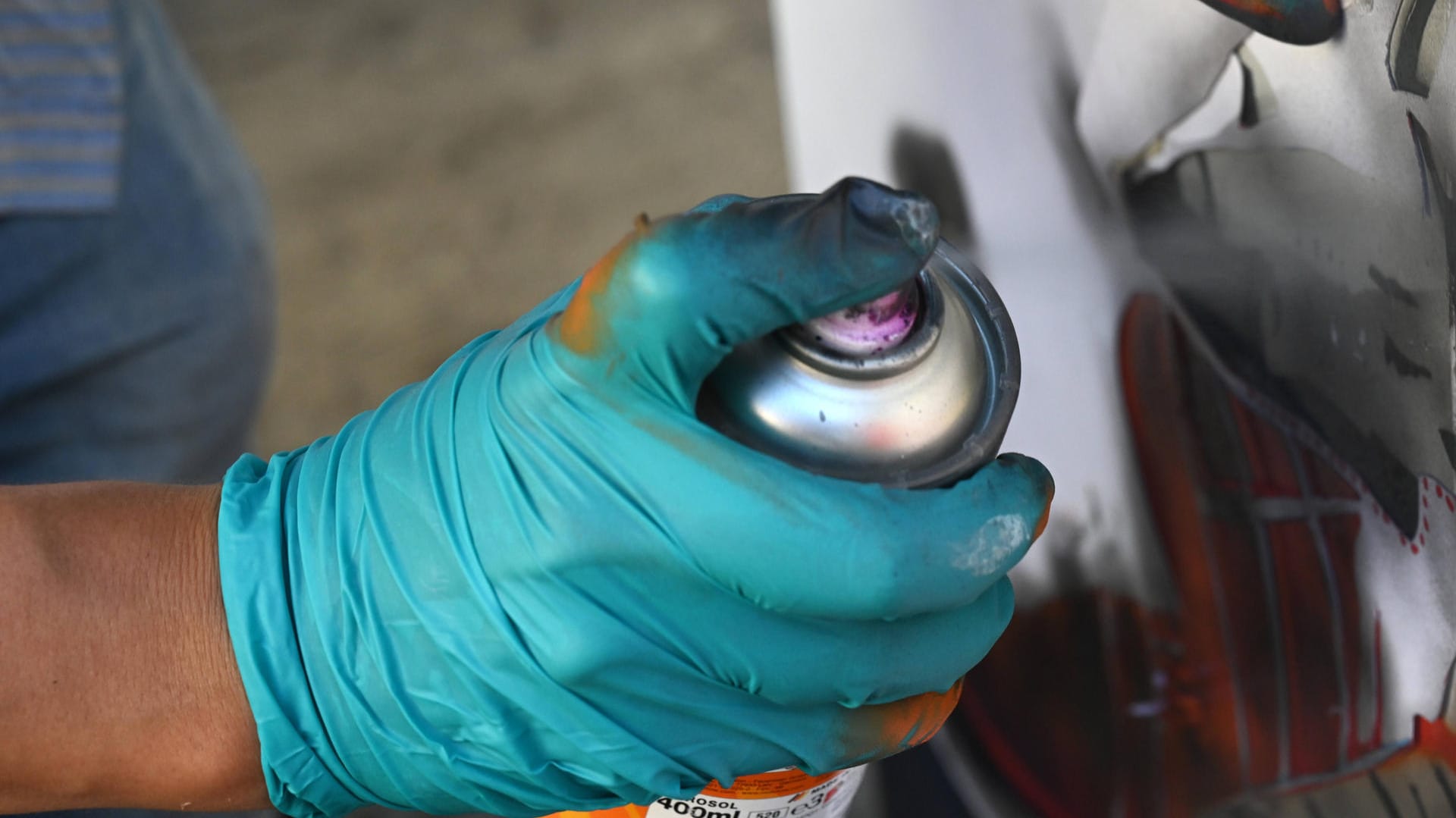 Hand mit Gummihandschuh hält eine Spraydose (Symbolbild): In Köln sind Bahnmitarbeiter auf Sprayer gestoßen. Hand mit Gummihandschuh hält eine Spraydose (Symbolbild): In Köln sind Bahnmitarbeiter auf Sprayer gestoßen.