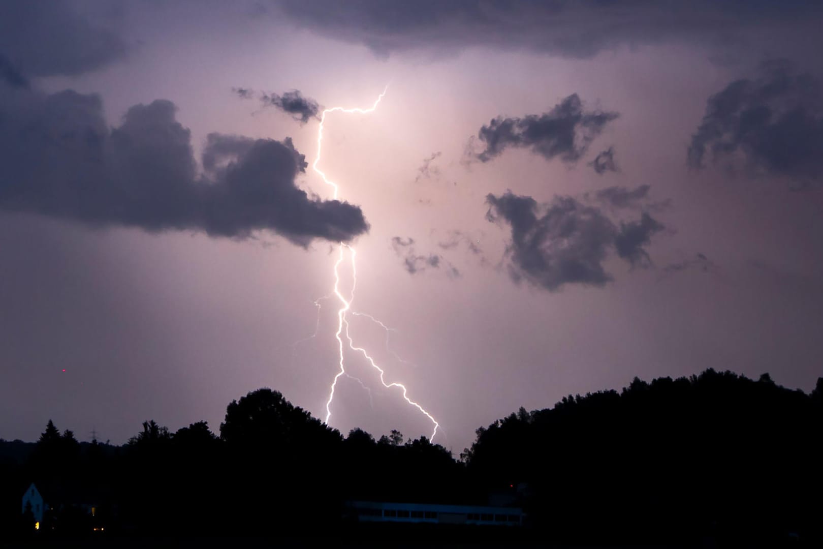 Ein Blitz erhellt den Nachthimmel: Heftige Regenfälle und Gewitter für überflutete Keller und Straßen gesorgt.