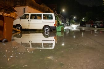 Wasser steht auf einer Straße in Wolfratshausen: Für die Nacht zum Dienstag hatte der Deutsche Wetterdienst vor allem in Baden-Württemberg und Bayern Gewitter, Starkregen und orkanartige Sturmböen vorher gesagt.