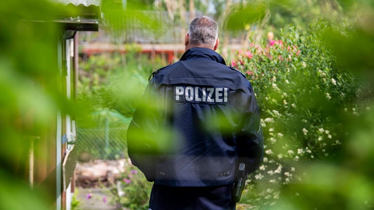 Polizist vor einer Gartenlaube in Münster: Die Ermittler deckten dort ein Netzwerk um sexuelle Gewalt an Kindern auf (Archivfoto).