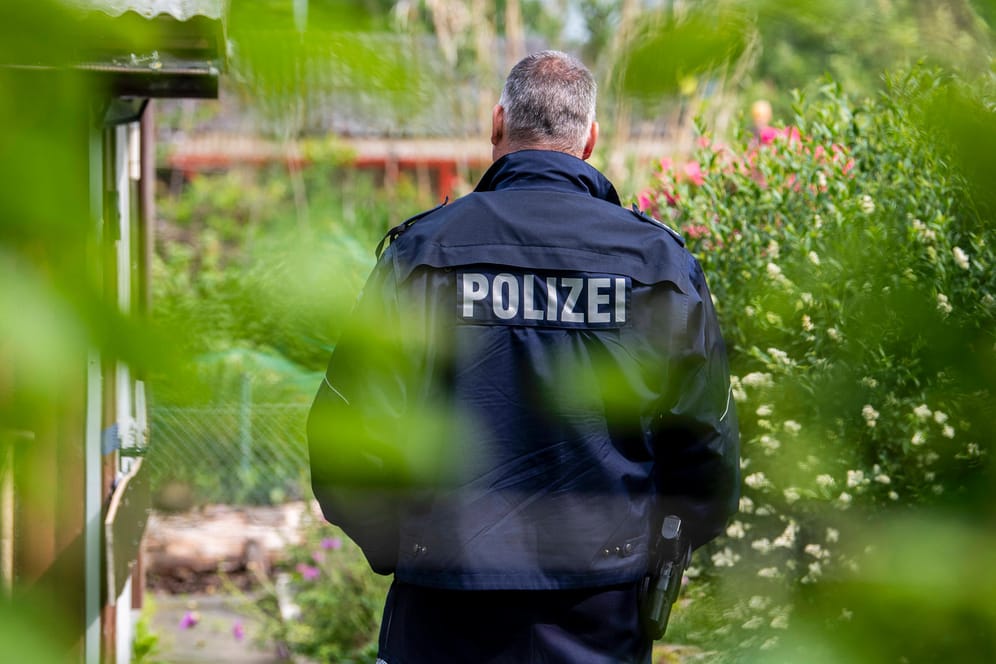 Polizist vor einer Gartenlaube in Münster: Die Ermittler deckten dort ein Netzwerk um sexuelle Gewalt an Kindern auf (Archivfoto).
