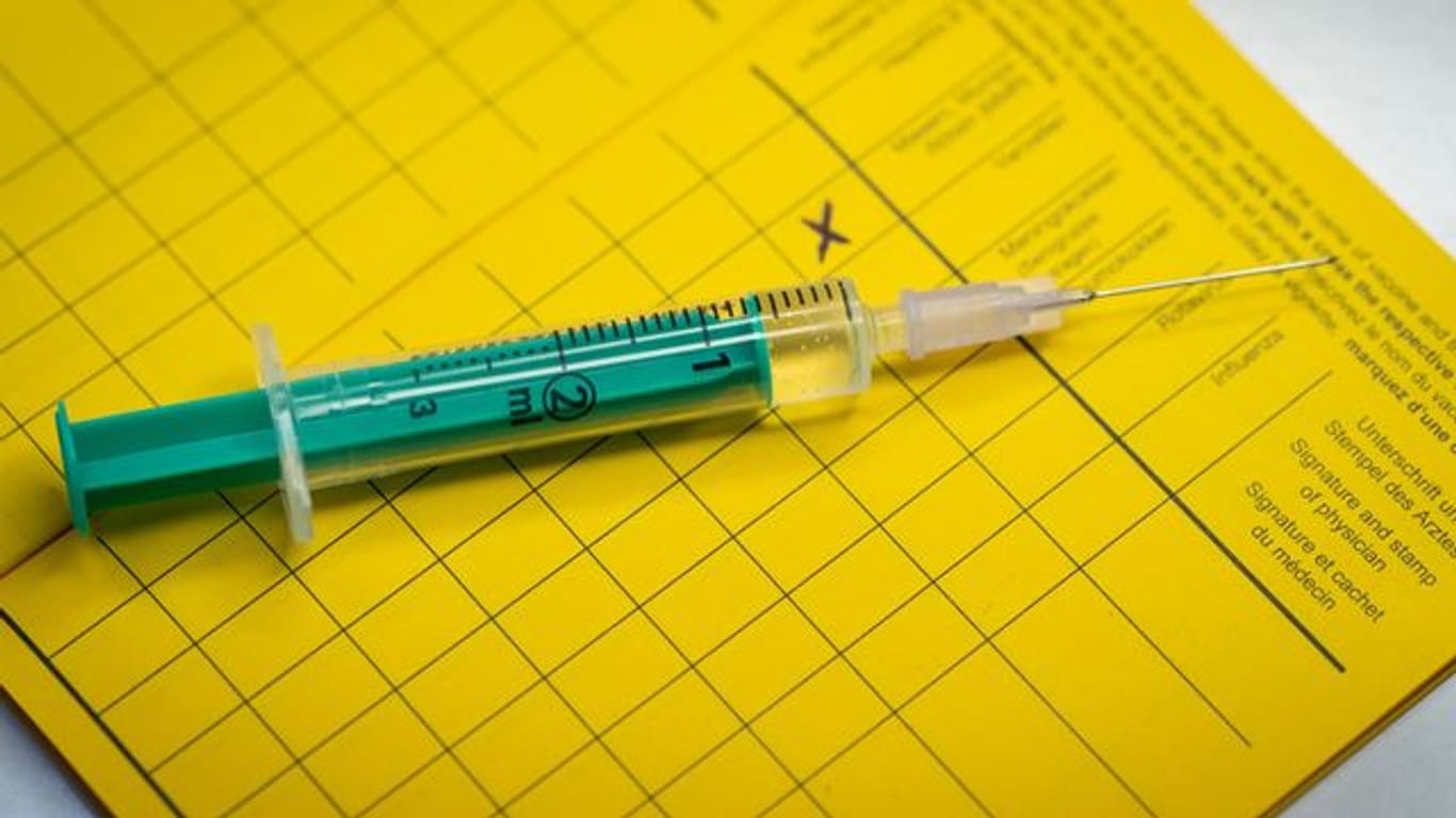 Eine Spritze liegt auf einem Impfpass (Symbolbild): Ab sofort können die Termine gebucht werden.