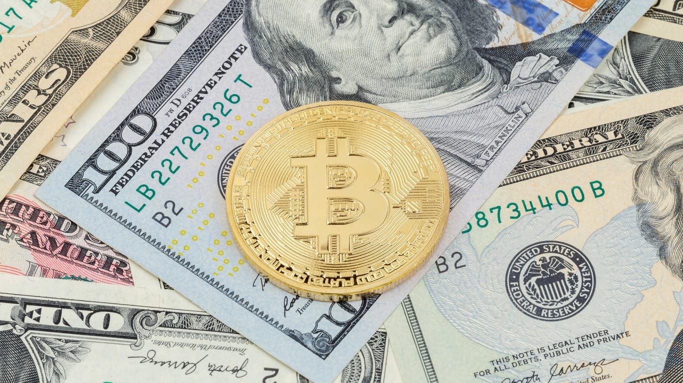 Bitcoin auf Dollarschein (Symbolbild): Der Kurs der Digitaldevise fällt seit Tagen.