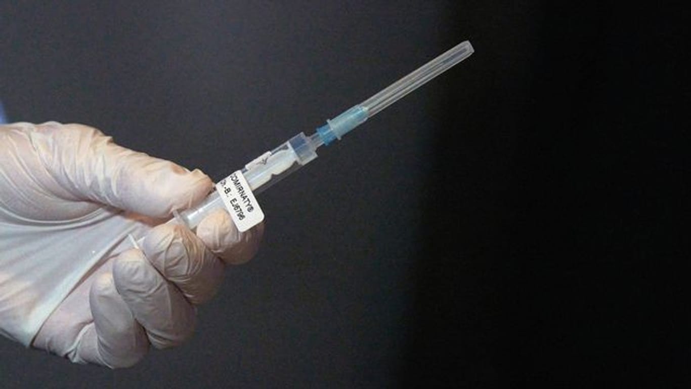 Eine Mitarbeiterin eines Impfteams überprüft eine Spritze