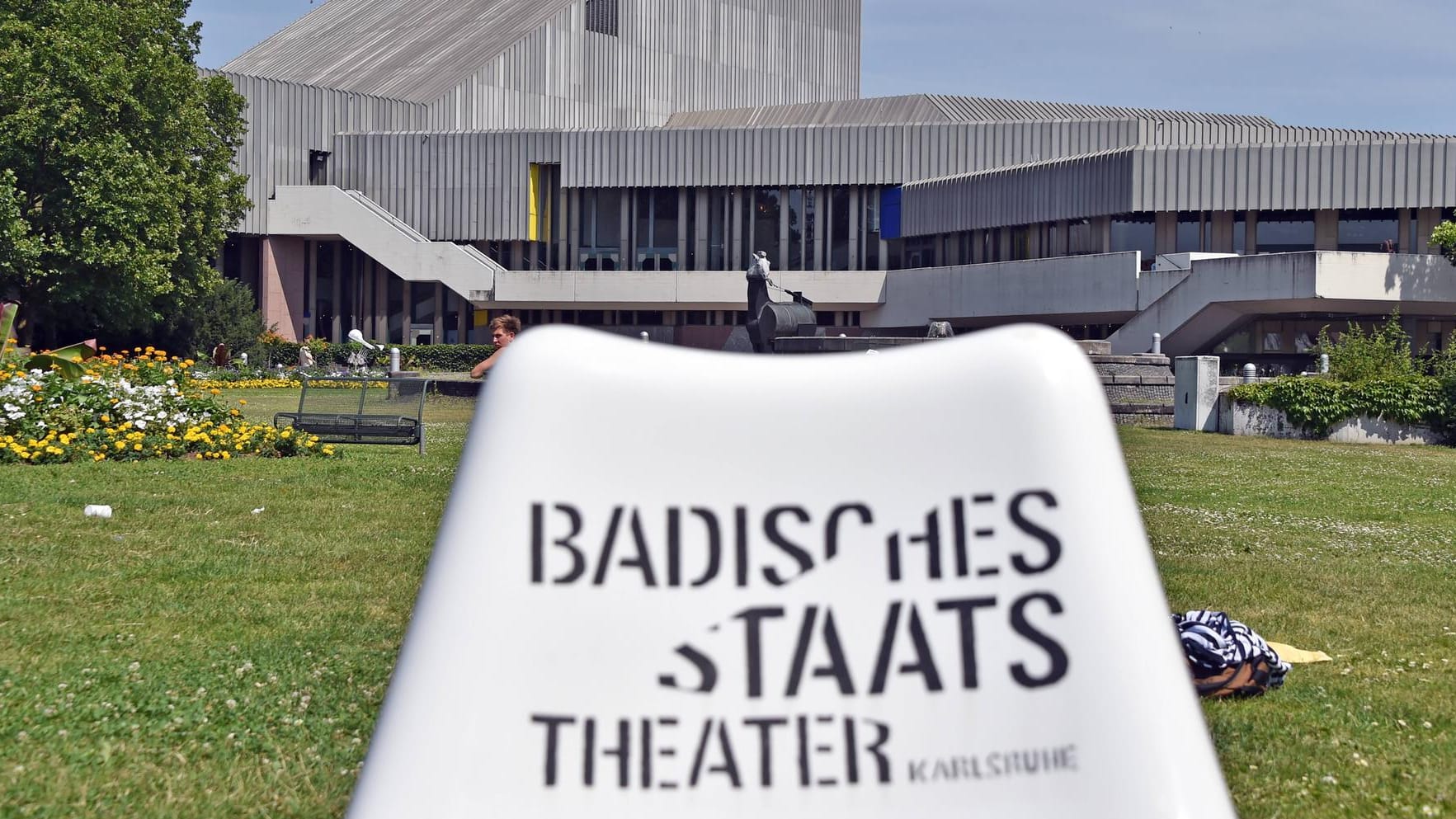 Das Badische Staatstheater spiegelt sich in einer Wasserfläche (Archivbild): Das Haus wird für viel Geld saniert.