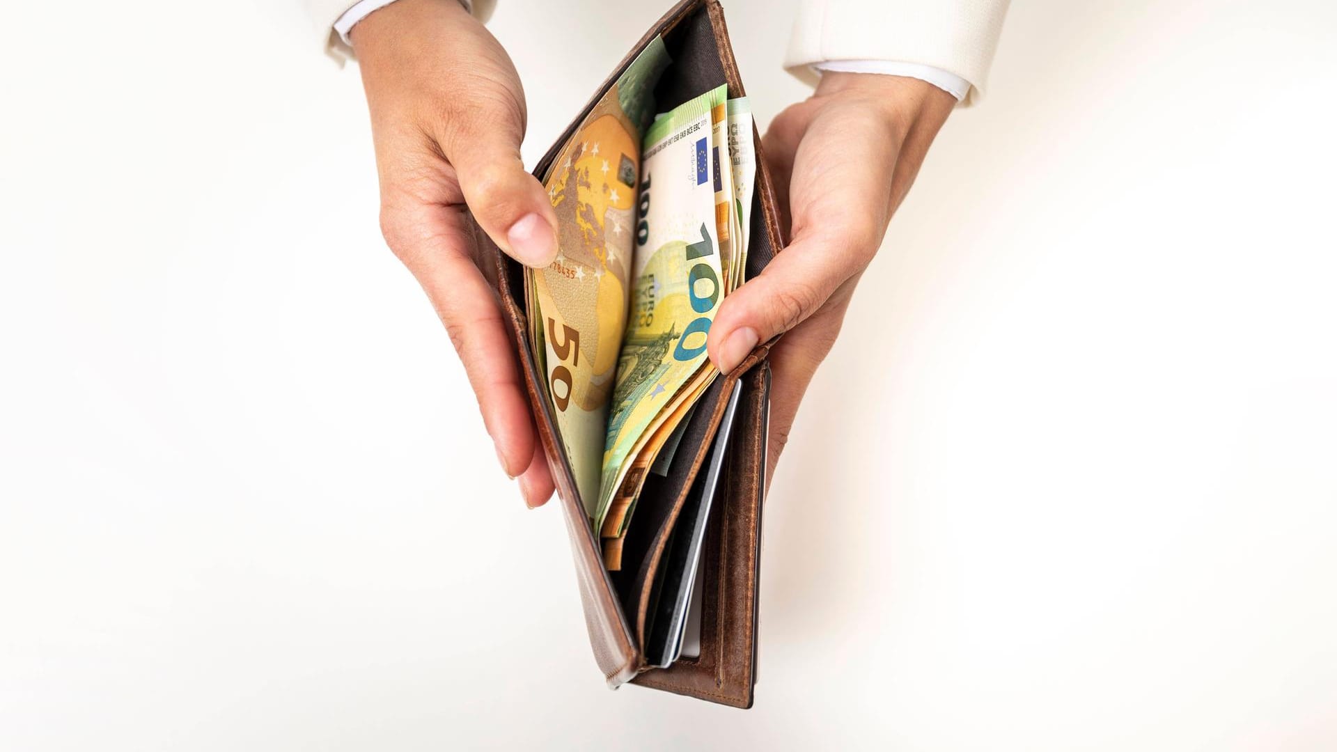 Frau, Hände halten Geldbörse mit Geldscheinen (Symbolbild): Dem Eigentümer war das Portemonnaie vermutlich beim Radfahren hingefallen. Frau, Hände halten Geldbörse mit Geldscheinen (Symbolbild): Dem Eigentümer war das Portemonnaie vermutlich beim Radfahren hingefallen.