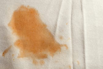 Fleck auf einem T-Shirt: Wer Flecken direkt mit Handseife behandelt, hat eine Chance, dass sie nach dem Waschen in der Maschine verschwinden.