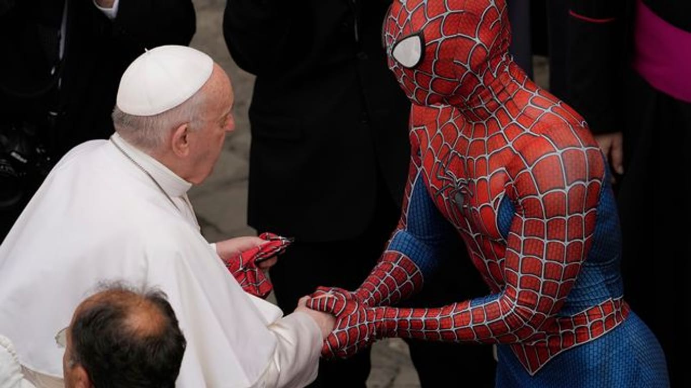 Papst Franziskus (l) spricht am Ende seiner wöchentlichen Generalaudienz mit einem Mann im Spiderman-Kostüm.