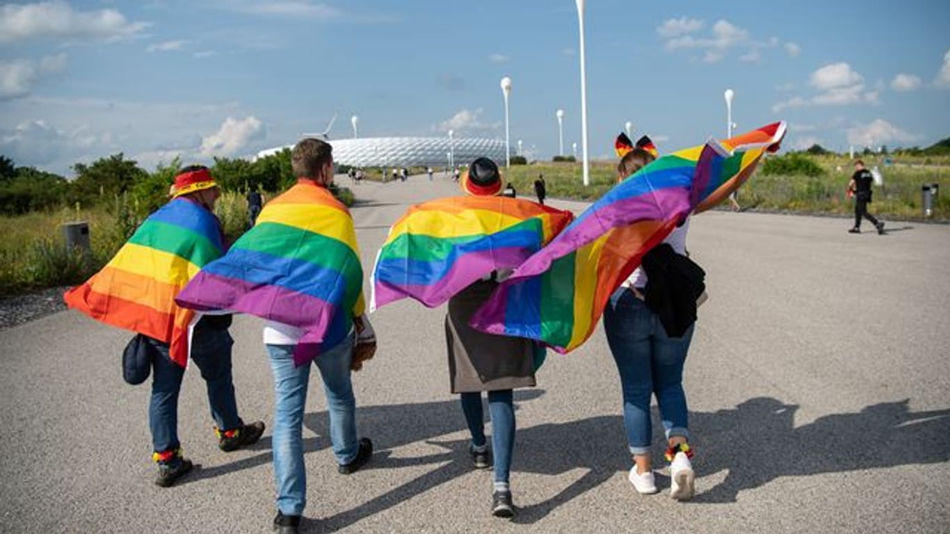 Fußballfans mit Regenbogenfahnen vor dem Spiel in München