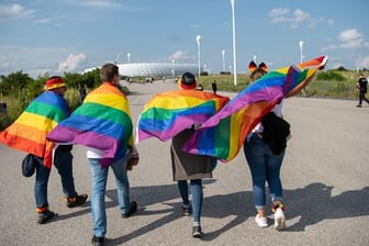 Fußballfans mit Regenbogenfahnen vor dem Spiel in München