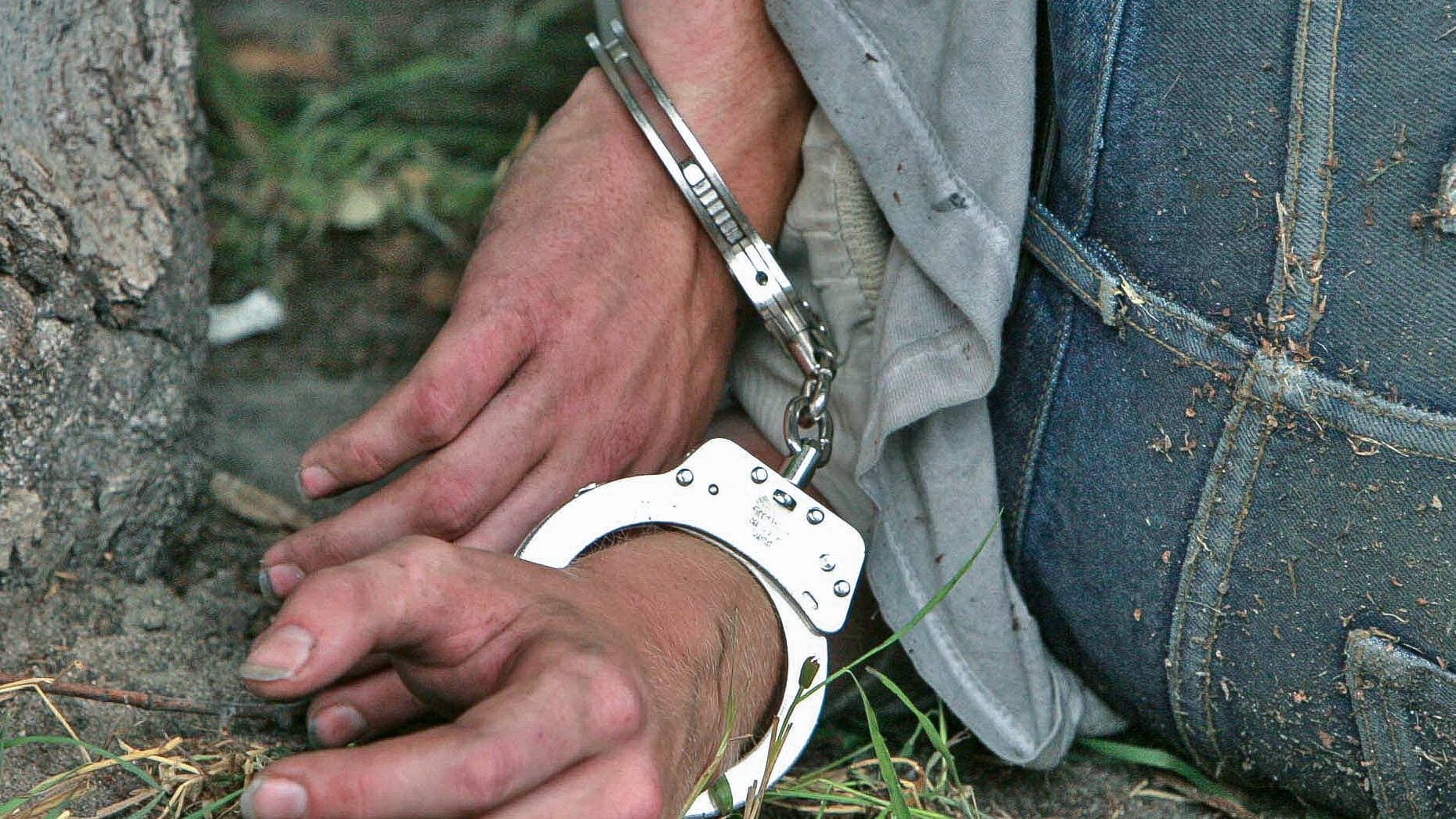 Ein Täter liegt in Handschellen auf dem Boden (Symbolfoto): So erging es wohl einem falschen Wasserwerker in Essen.