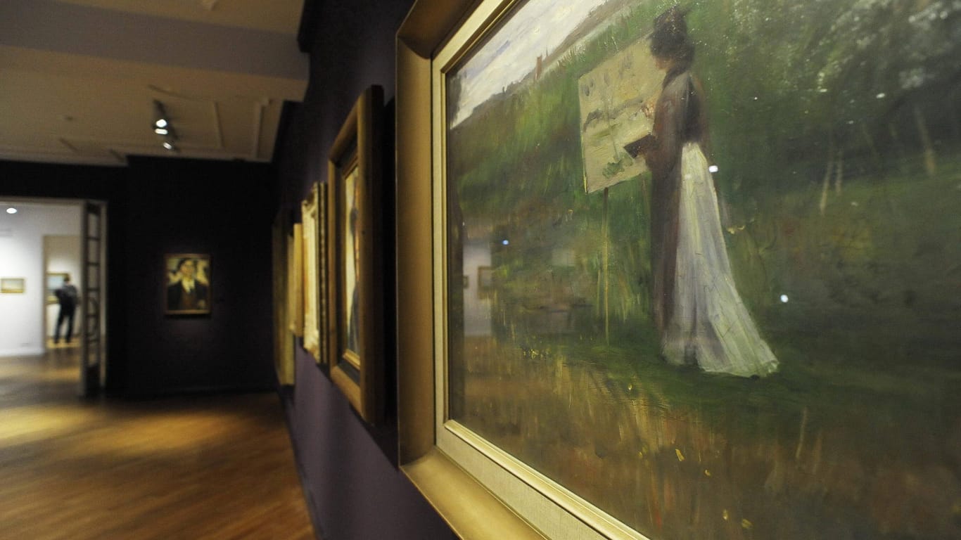 1/ Lovis CORINTH: Das Gemälde "Die Malerin Charlotte Berend an der Staffelei" von Lovis Corinth ist in einer Ausstellung zu sehen (Symbolbild): In München werden beschlagnahmte Werke des Künstlers ausgestellt.
