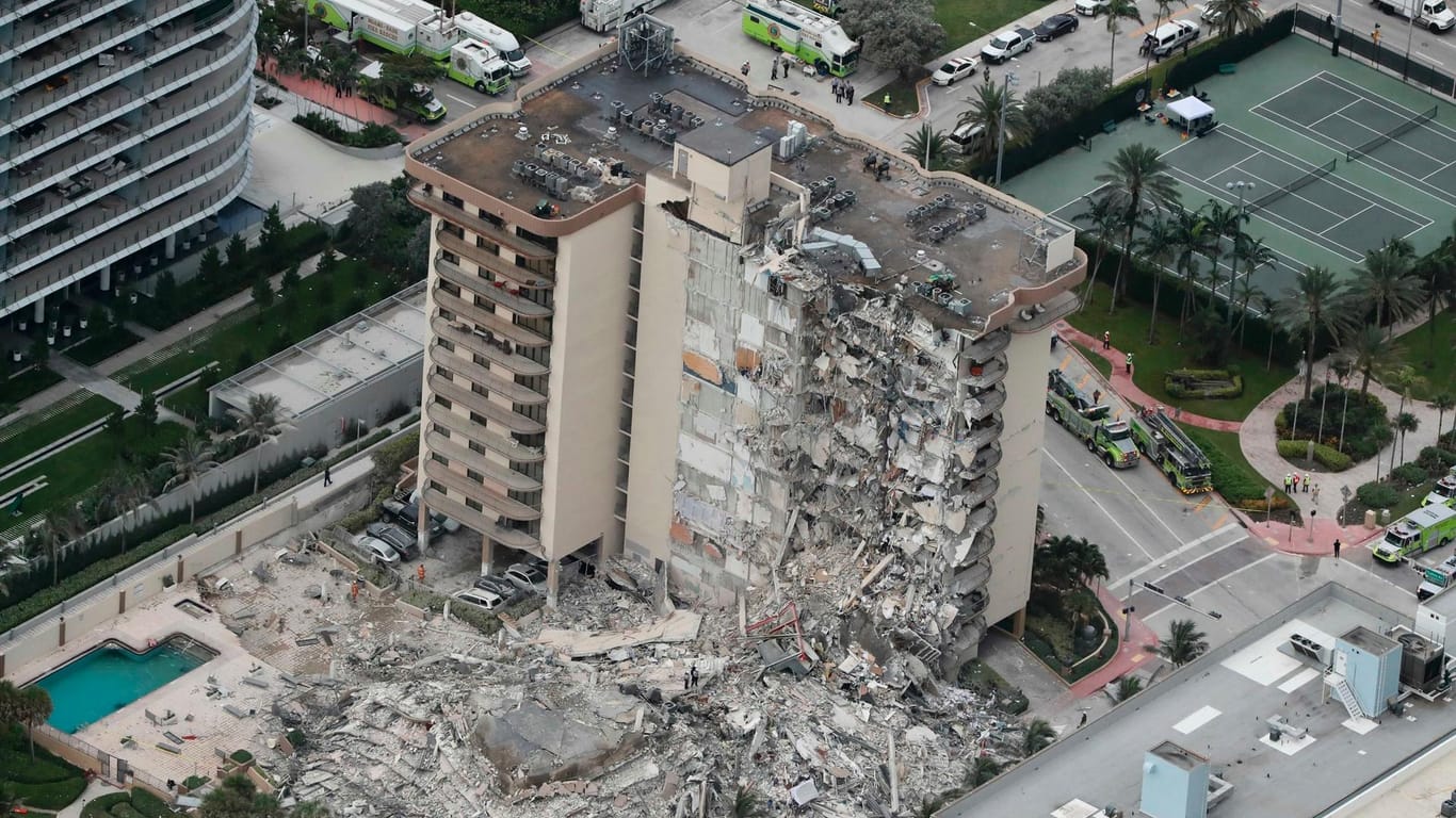 Trümmer liegen vor dem teilweise eingestürzten Champlain Towers South Condo: Mindestens eine Person ist bei dem Gebäudeeinsturz ums Leben gekommen.