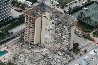 Trümmer liegen vor dem teilweise eingestürzten Champlain Towers South Condo: Mindestens eine Person ist bei dem Gebäudeeinsturz ums Leben gekommen.