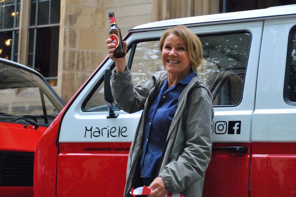 Mariele Millowitsch mit dem Tauf-Kölsch am Bulli "Mariele": Die Schauspielerin ist großer VW-Bus-Fan.