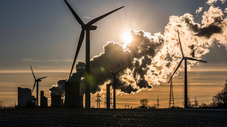 Windkrafträder vor dem Kohlekraftwerk Niederaußem (Archivbild): Ein neues Gesetz soll den Klimaschutz in Deutschland beschleunigen.