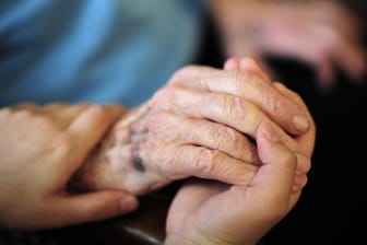 Eine Pflegekraft hält die Hand einer Seniorin (Symbolbild): Die häusliche Pflege wird bald deutlich teurer.