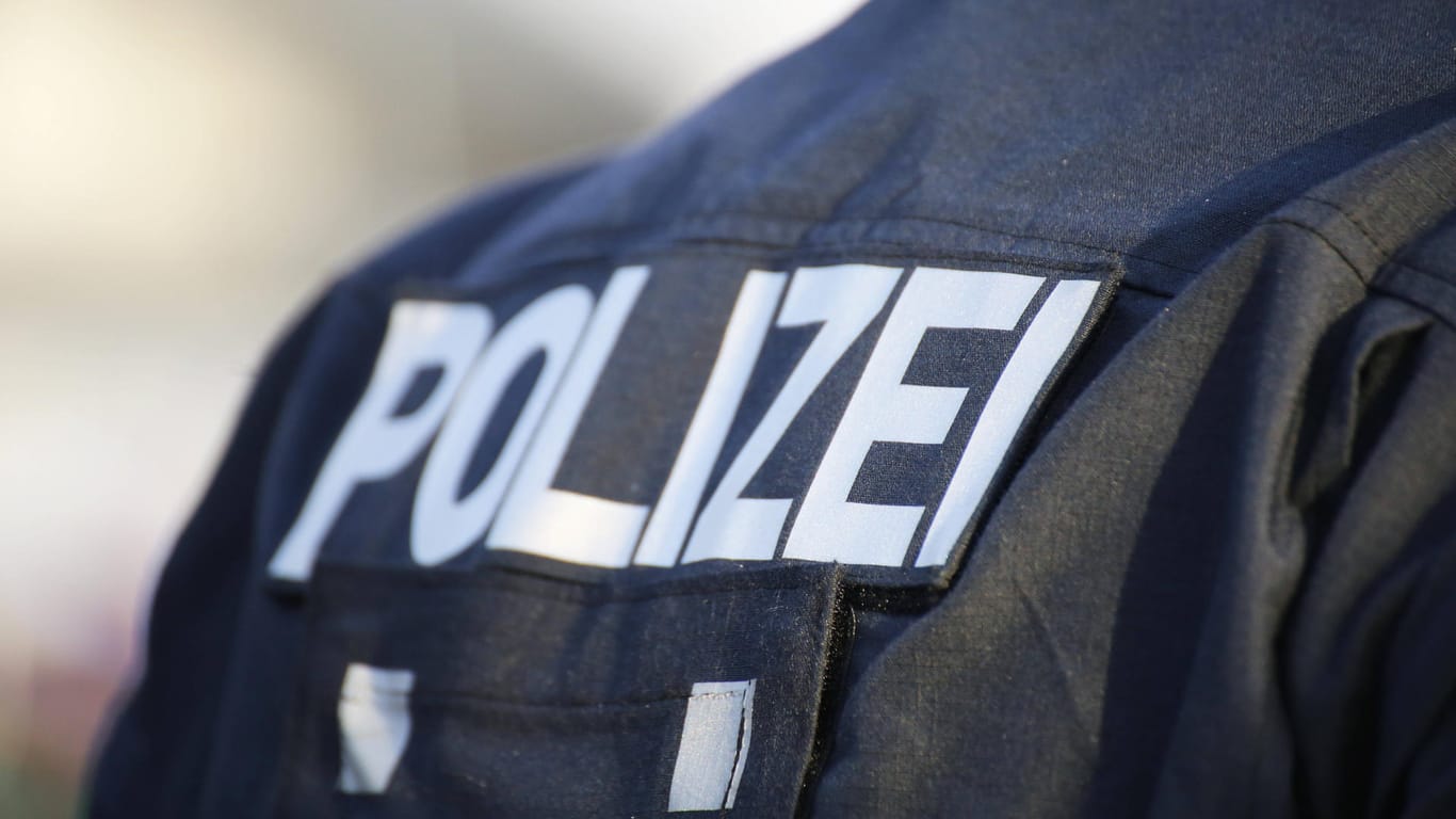 "Polizei" steht auf der Jacke eines Beamten (Symbolbild): Die Polizisten stellten eine Vielzahl von Artikeln sicher.