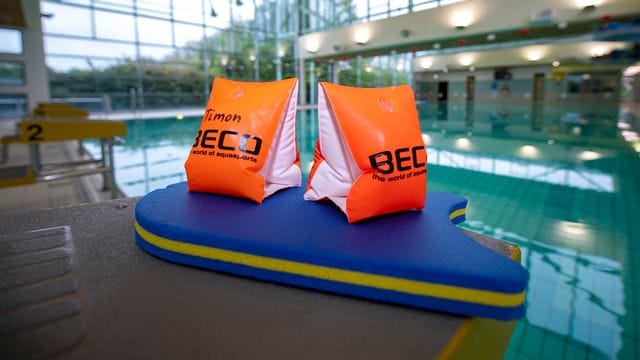 Zwei Schwimmflügel liegen auf einem Startblock Zwei Schwimmflügel liegen auf einem Startblock