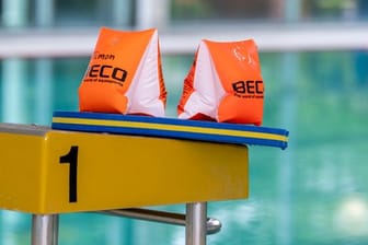 Zwei Schwimmflügel liegen auf einem Startblock