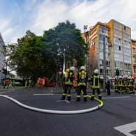 Die Feuerwehr Köln auf der Kreuzung an der Aachener Straße: Das Dach eines Mehrfamilienhauses hat hier Feuer gefangen und musste gelöscht werden.