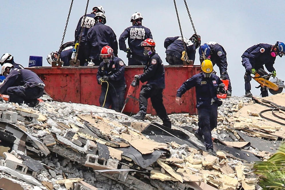 Rettungskräfte suchen nach Opfern und Überlebenden in den Trümmern der Wohnanlage.