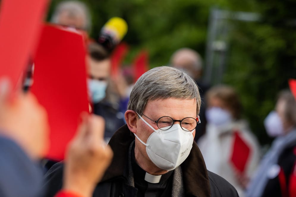 Kardinal Rainer Maria Woelki geht durch einen Spalier aus Gemeindemitgliedern, die ihm die Rote Karte zeigen (Archivbild): Der Kölner Erzbischof wird nicht freiwillig seinen Posten räumen.