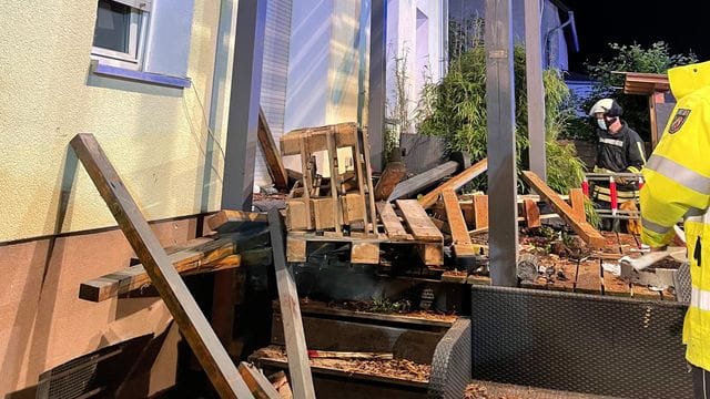 Rettungskräfte stehen neben den Trümmerteilen des eingestürzten Balkons: Noch ist unklar, wie es zu dem Einsturz kam. Rettungskräfte stehen neben den Trümmerteilen des eingestürzten Balkons: Noch ist unklar, wie es zu dem Einsturz kam.