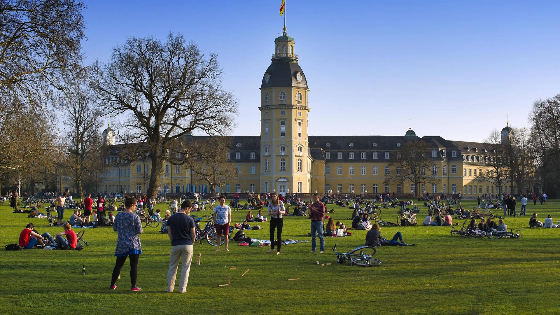 Menschen sitzen bei schönem Wetter im Schlossgarten in Karlsruhe (Archivbild): Die Polizei musste hier Platzverweise erteilen.