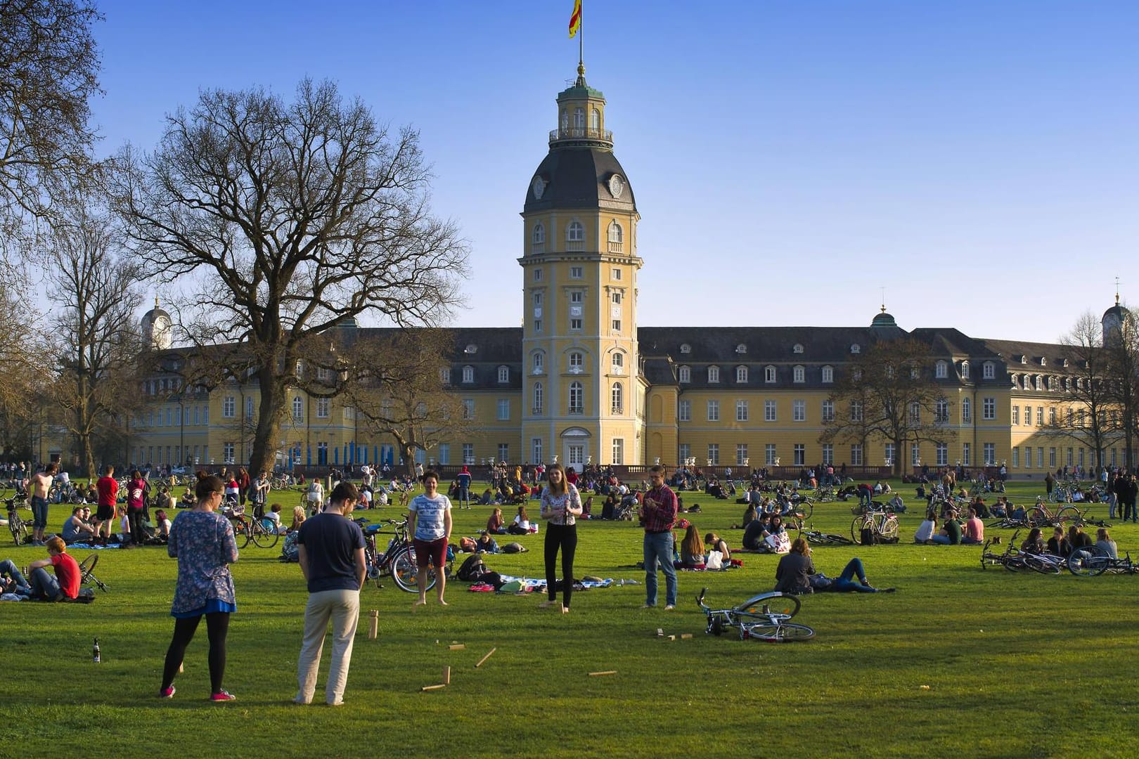 Menschen sitzen bei schönem Wetter im Schlossgarten in Karlsruhe (Archivbild): Die Polizei musste hier Platzverweise erteilen.